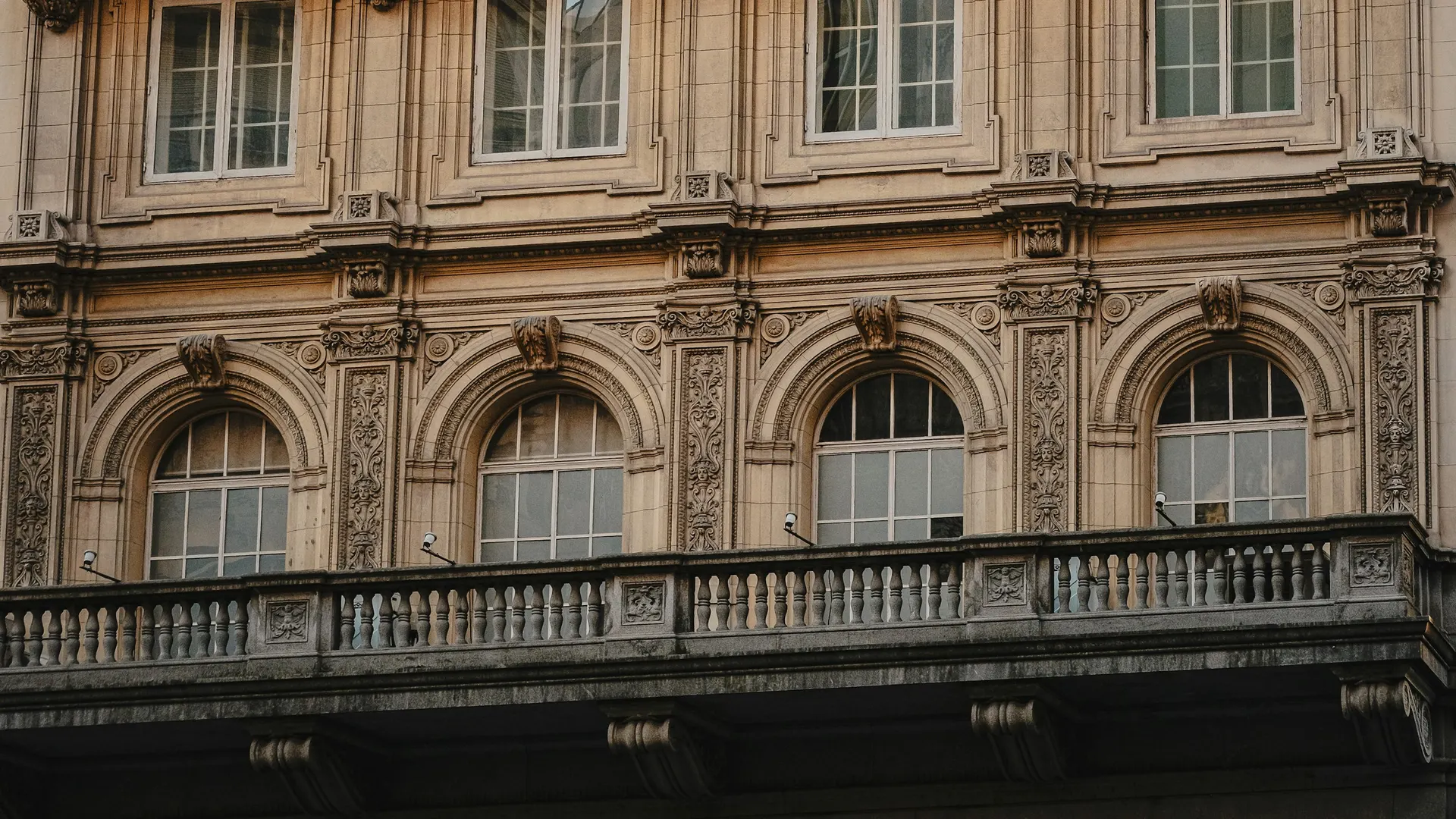 Fachada academicista de un edificio de Buenos Aires con balcón y ventanas en arco